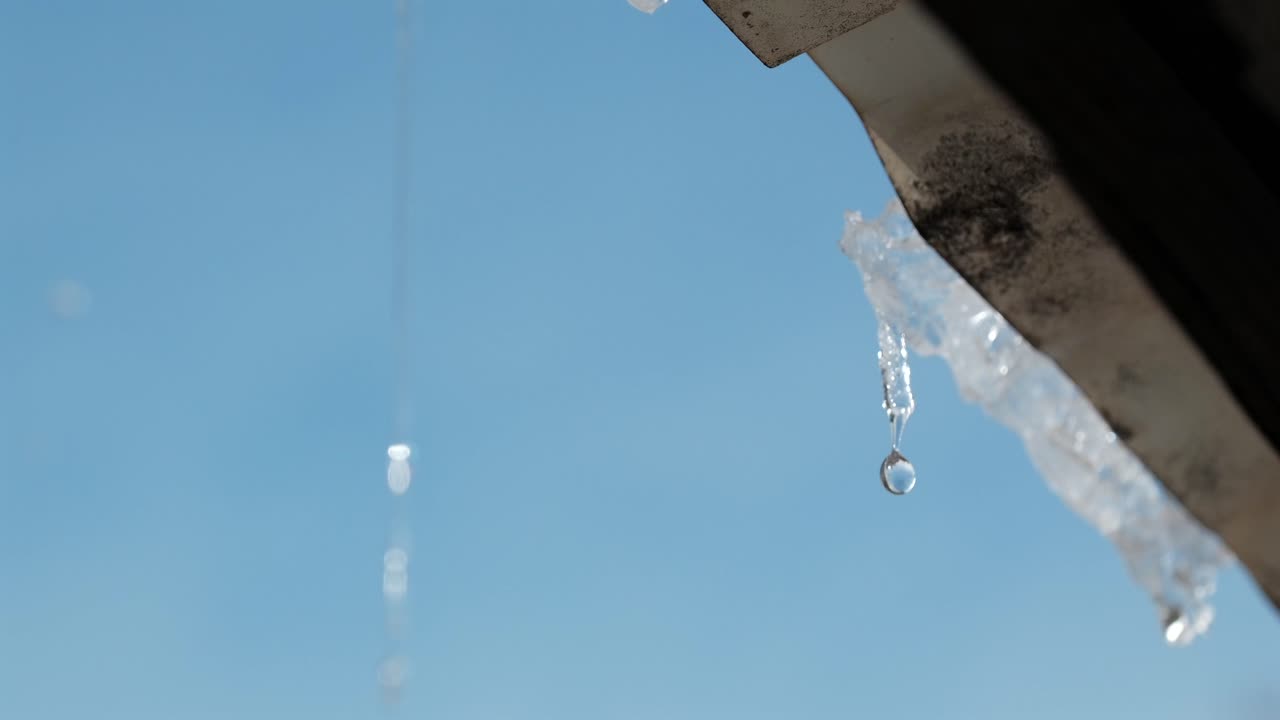 映画のようなスローモーションのクローズアップで、屋根から雪とつららが溶ける様子を捉えます。軒から滴る光り輝く水は、自然の融解プロセスと変化する季節の環境を表現しています。