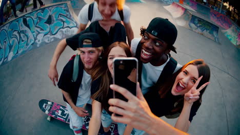 friends taking selfies at a skatepark at sunset