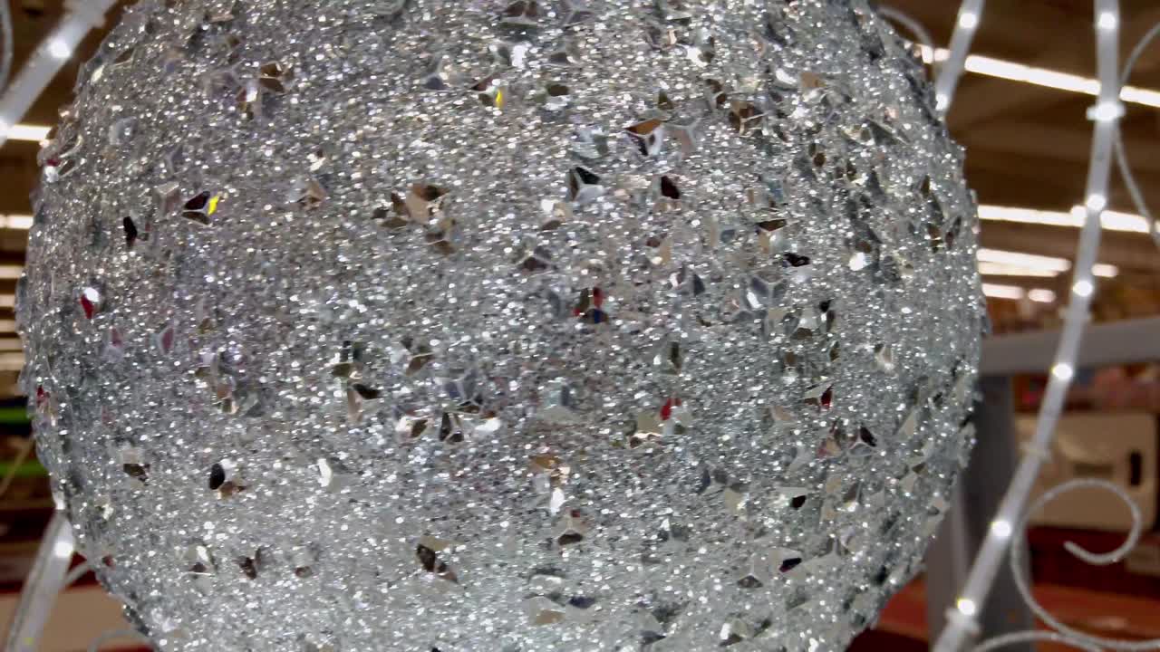 Sparkling silver globe with shimmering crystals in store setting