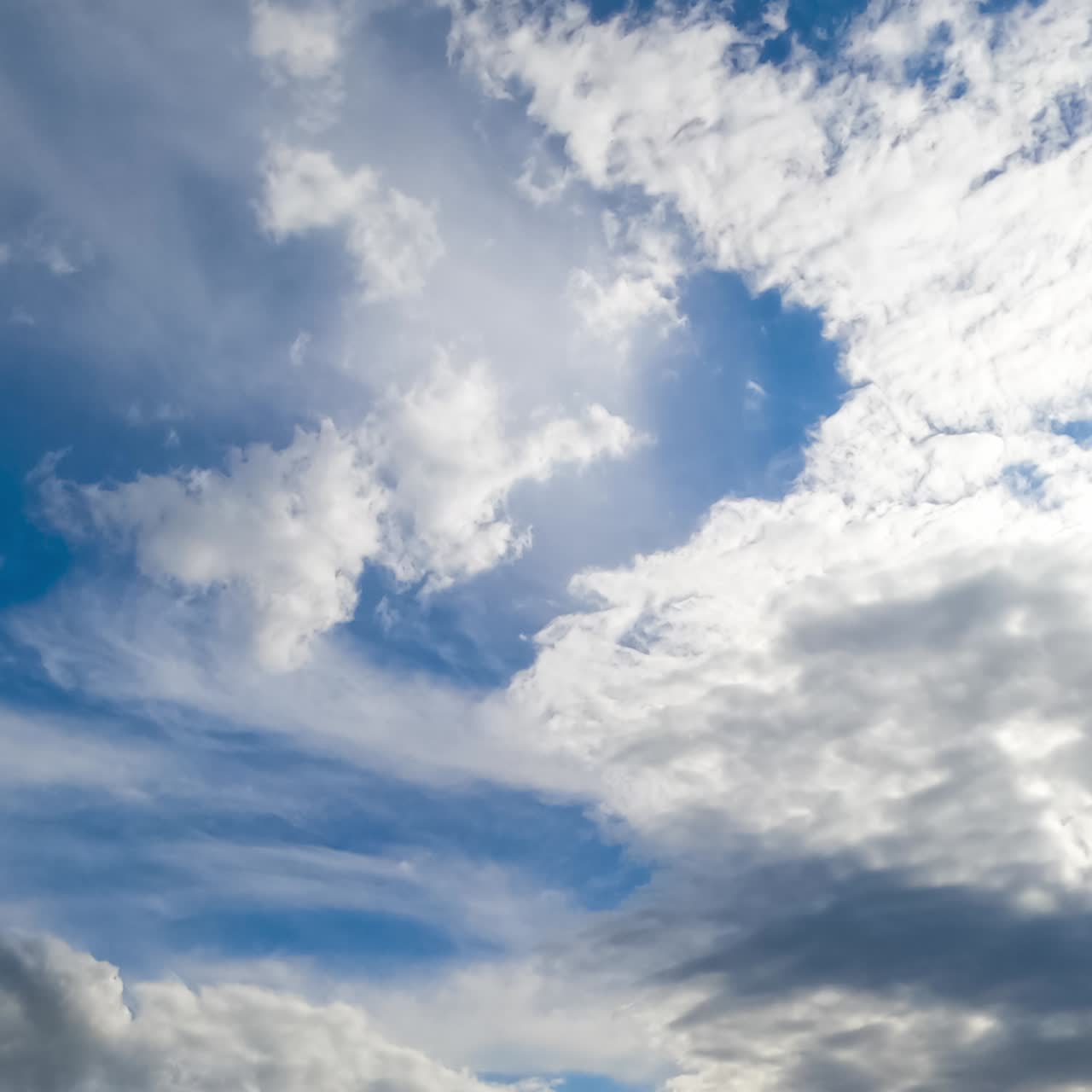 White soft clouds moving quickly by the horizon. Cloudscape formation low angle view. Timelapse