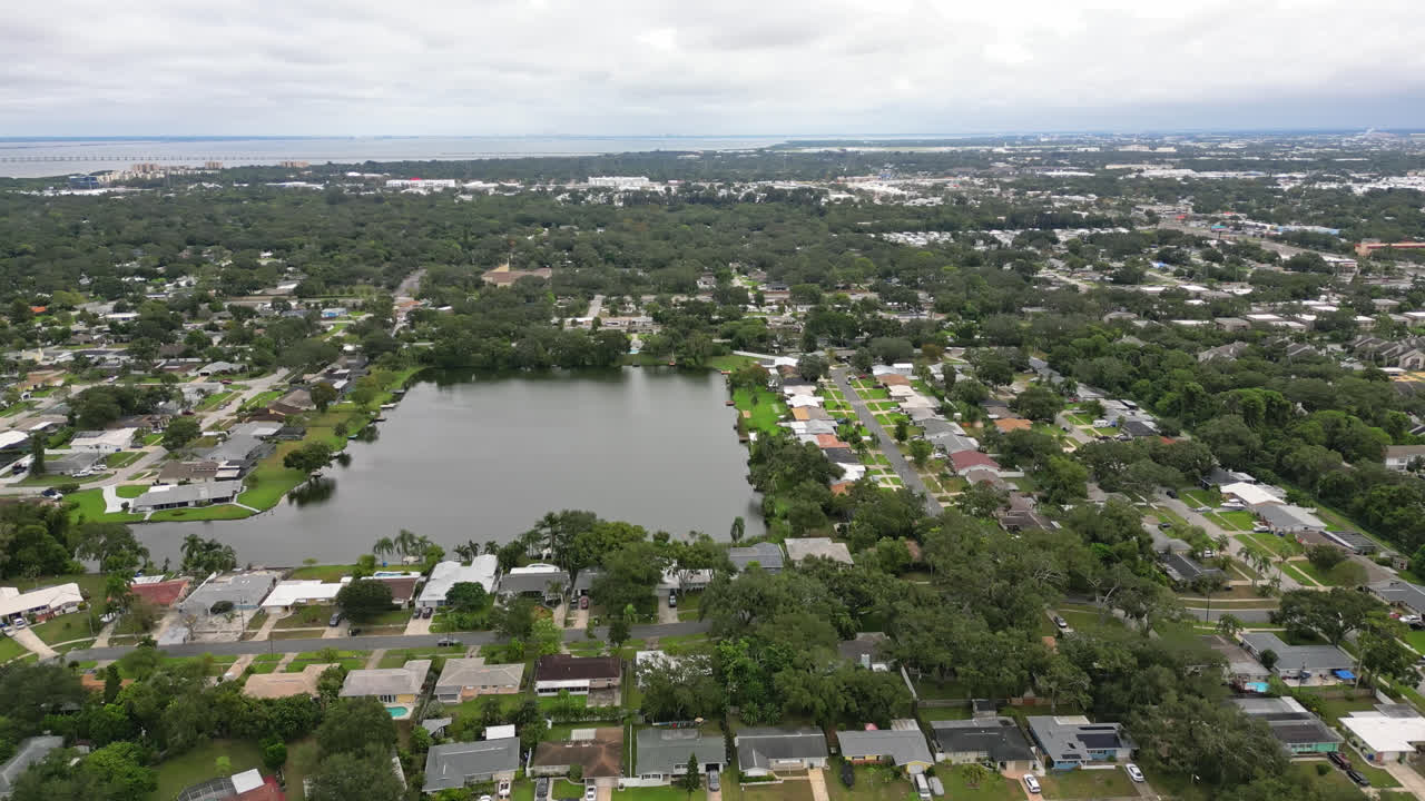 Aerial flyover of a suburban neighborhood built along canals, various waterways and a small lake