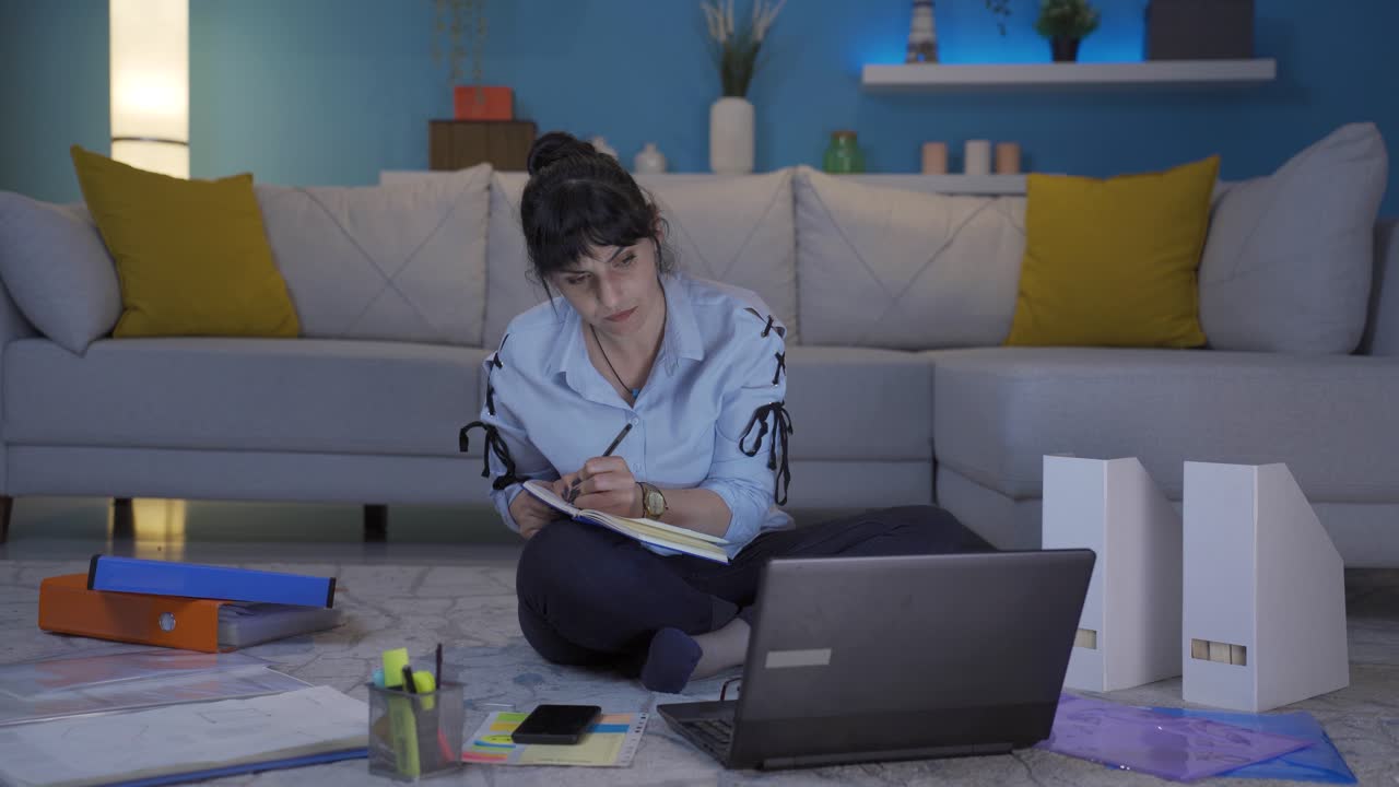 mujer trabajadora de oficina en casa tomando notas, anotando información.