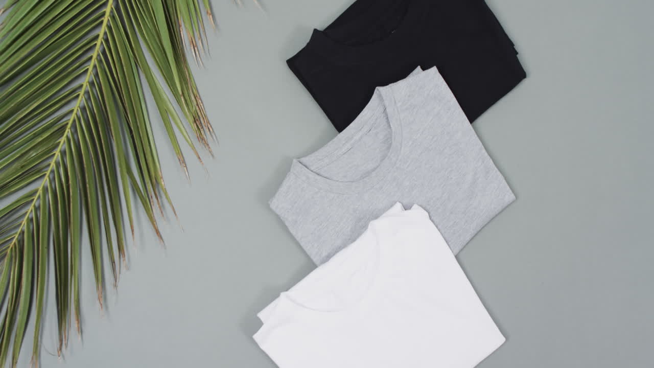 video de una capa plana de camisetas con espacio de copia en un fondo gris