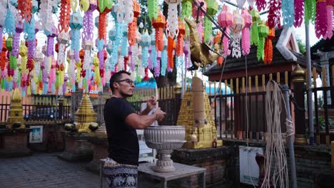 man making an offering at a thai temple