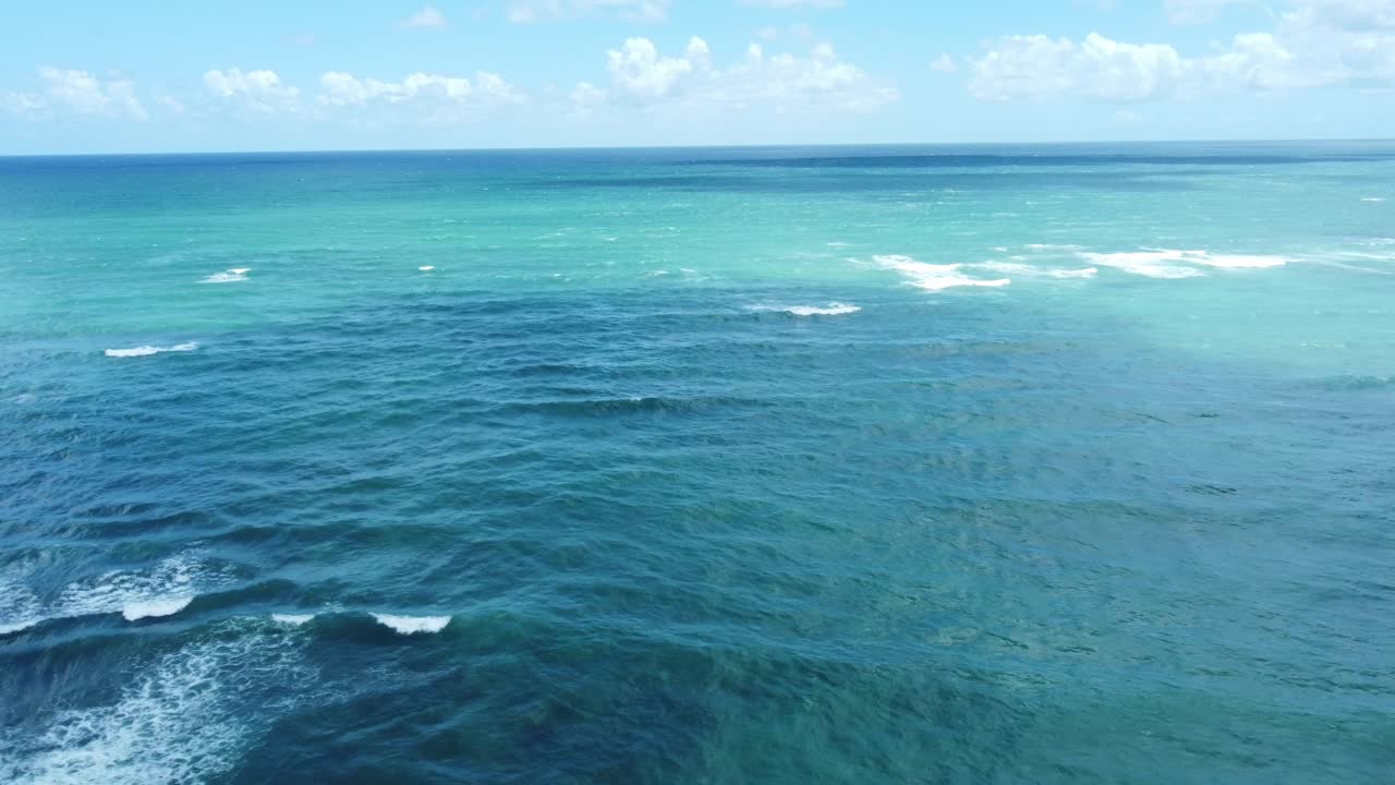 공중 드론은 오아후 해양의 투명한 물을 포착하여 활기찬 파란색 색조와 해안선을 따라 부히는 파도의 역동적인 패턴을 놀라운 세부 사항으로 보여줍니다.