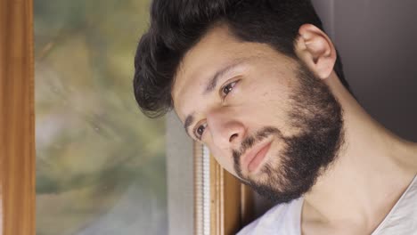 depressed man looking out the window thoughtfully.