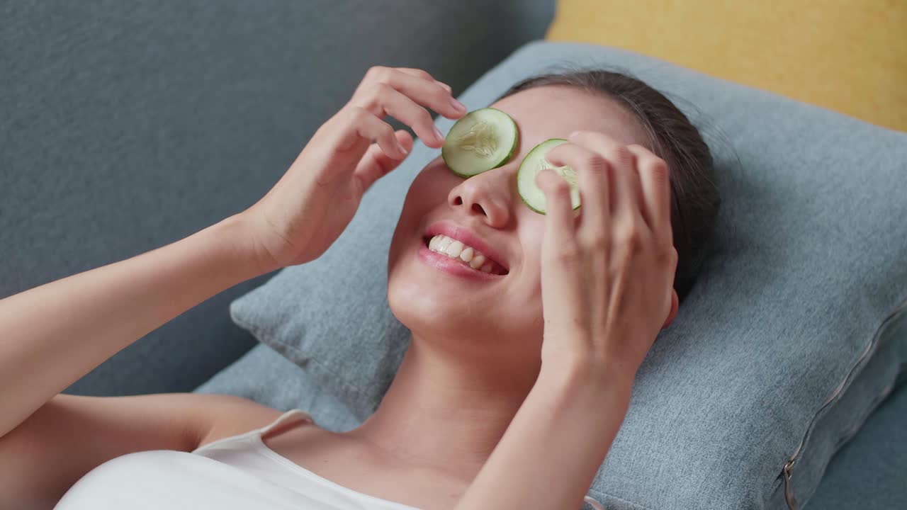 キュウリの眼マスク治療を楽しんでいる女性