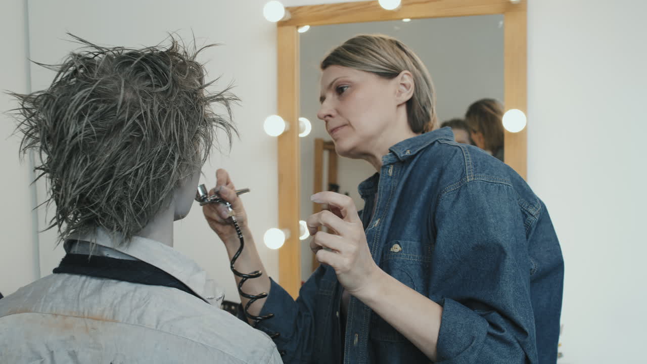 SFX Makeup Artist Using Airbrush Machine on Client