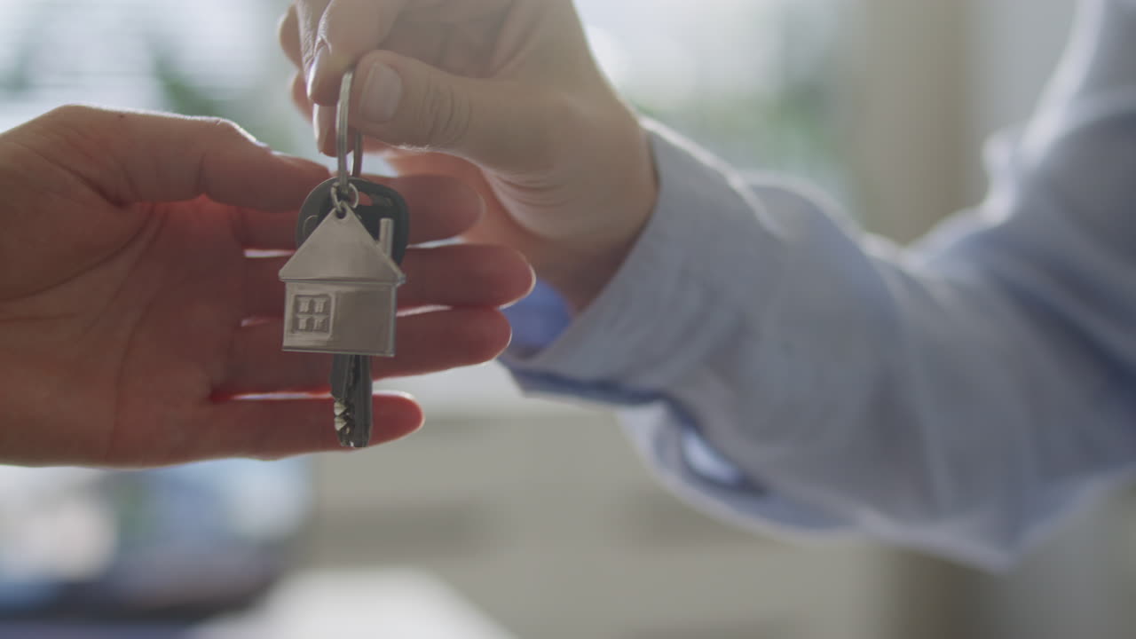 Primo piano di un agente immobiliare che consegna le chiavi di casa al proprietario