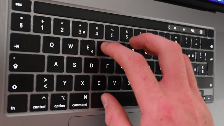 A copywriter is working behind his laptop, typing on the keyboard, online messages