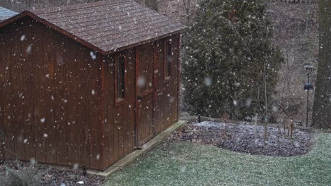 first snowfall of the year over wooden shed, slow motion high angle