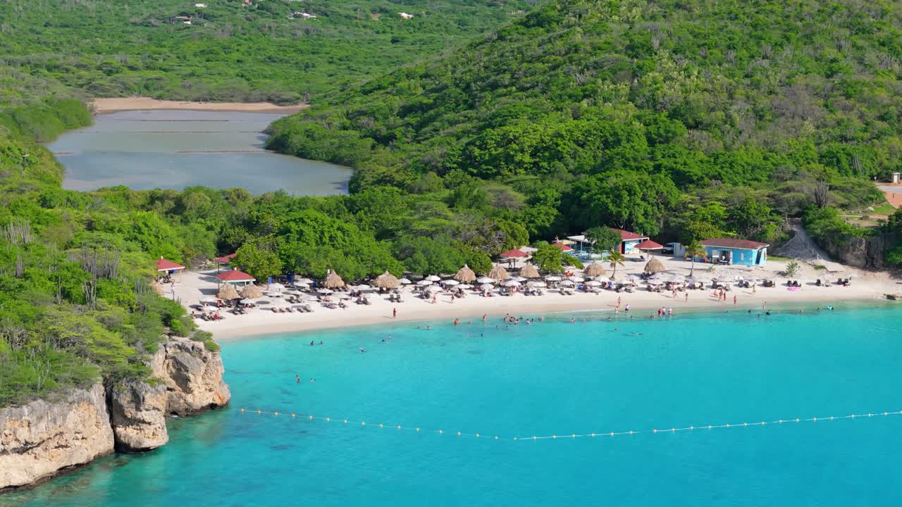 Drone pullback descend establishes Grote Knip Curacao white sandy beach in tropical Caribbean island