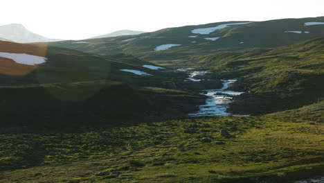 Panorámica-De-Campos-Verdes-Y-Montañas-Nevadas-A-La-Entrada-Del-Verano-En-Stekenjokk,-Suecia