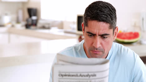 man reading newspaper and having coffee in the morning