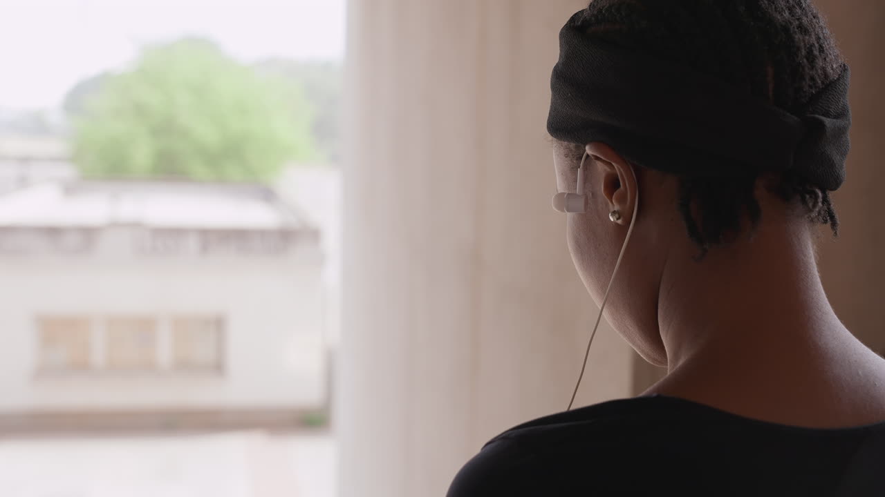 Ragazza guarda fuori. Donna osserva tranquillamente attraverso la finestra. Ragazza osserva all'esterno attraverso la finestra con serena tranquillità. Donna osserva tranquillamente il mondo esterno attraverso la finestra con pacata riflessione.