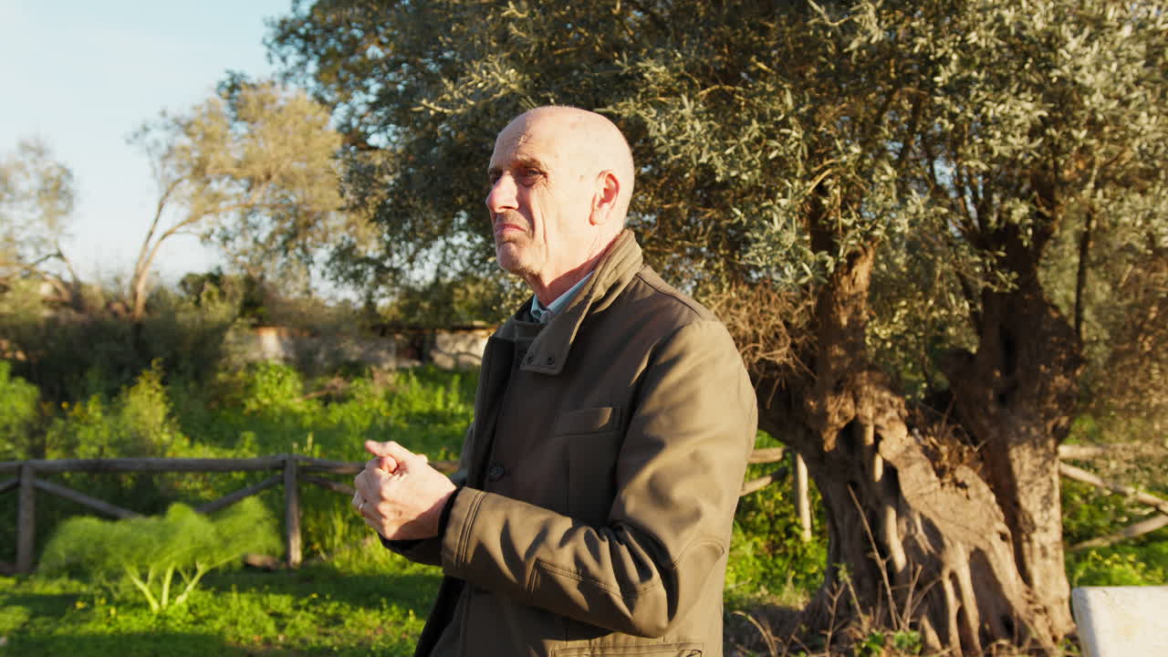 Old Man Rubs His Hands Under the Sun in Nature
