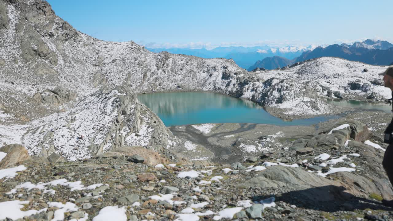 발말렌코 (valmalenco) 에서 산길을  ⁇ 고 산 호수를 지나가는 남자, 슬로모