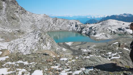 hombre caminando en una caminata en valmalenco, pasando por el lago de montaña, slowmo