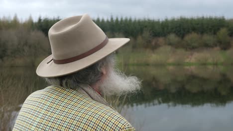 ein älterer mann, der auf den see blickt