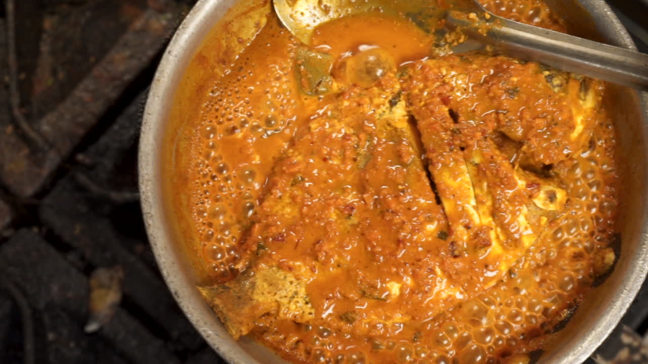 el pescado entero se hierve a fuego lento en salsa sobre la estufa, cierre el control deslizante superior hd