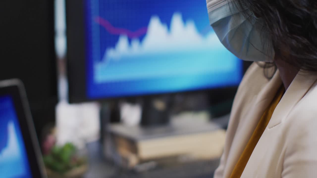 mujer con máscara facial desinfectando sus manos en la oficina