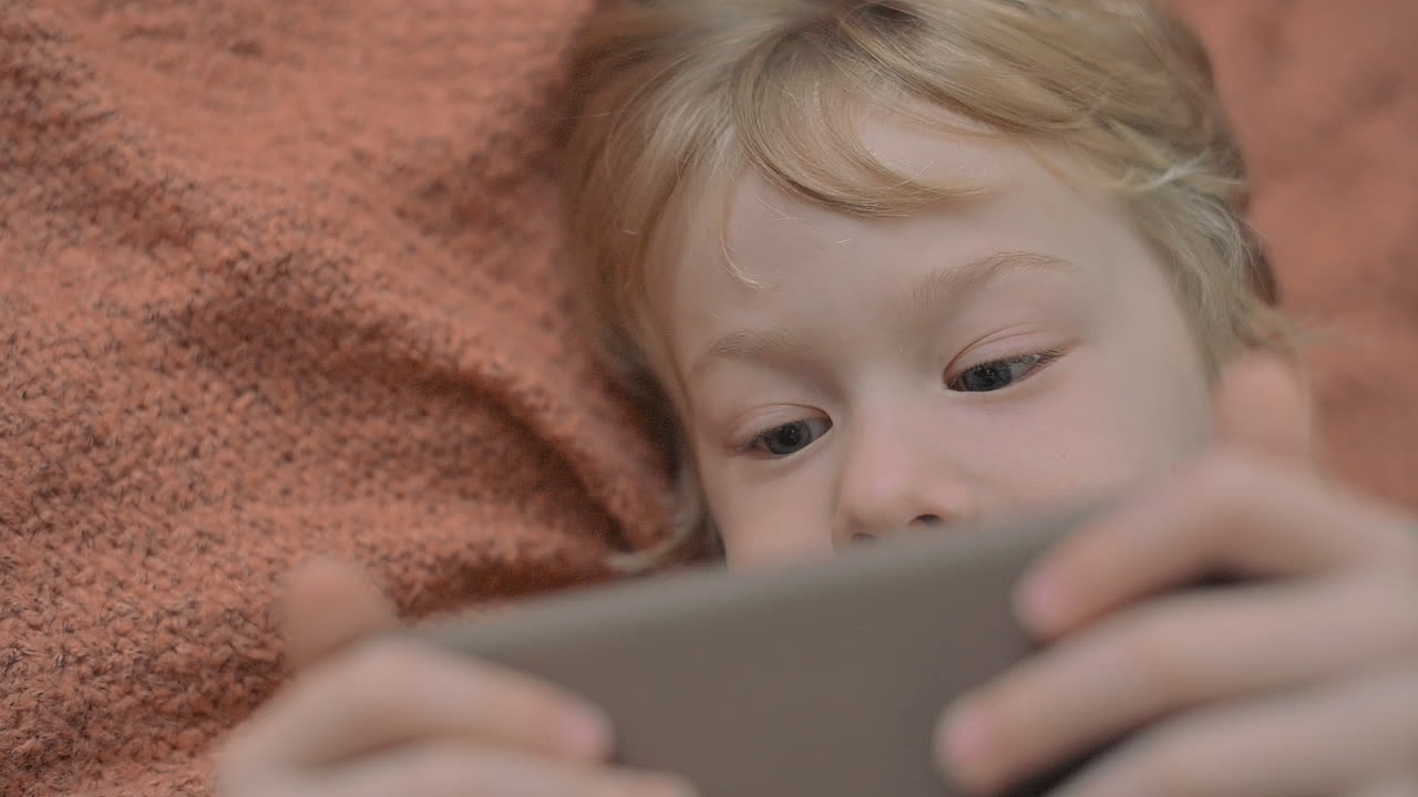 Cute Girl Lies On The Sofa At Home And Listen To Music While Playing With Her Dog Lovingly