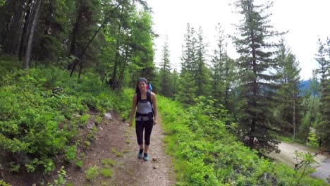 Mother-carrying-baby-in-carrier-backpack-while-walking-through-forest-4k