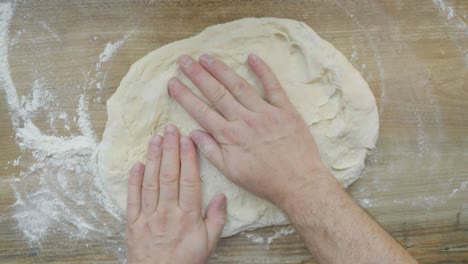 kneading dough by hand while working on homemade buns