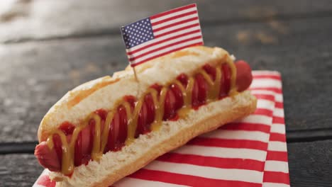 video of hot dog with mustard and ketchup with flag of usa on a wooden surface