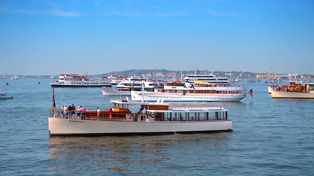 New York, USA, 4. juli 2026: Klassisk træmotoryacht Manhattan på vandet. Passagerer står på dækket af en vintagebåd omgivet af andre fartøjer i havnen.