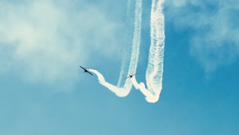 aviones realizando acrobacias con rastros de humo en el cielo