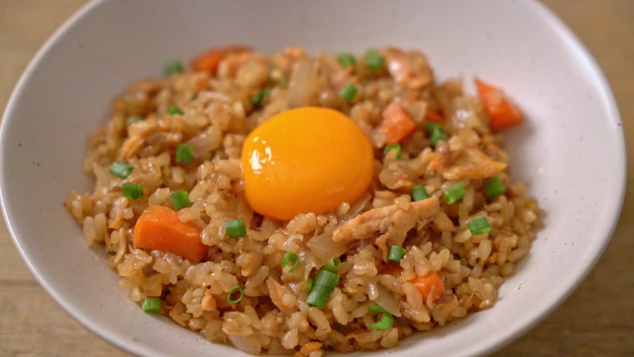 arroz frito con salmón con huevo en escabeche encima - estilo de comida asiática