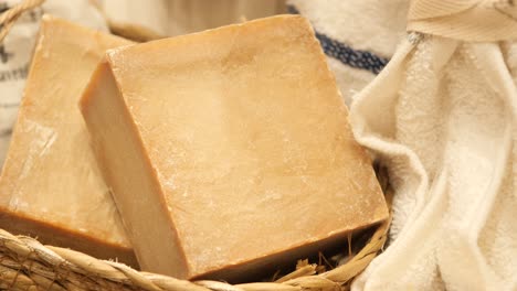 natural handmade soap bars in a basket with a towel