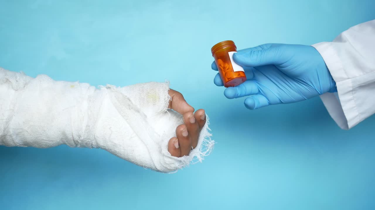medico che dà la medicina a un paziente con un braccio bendato
