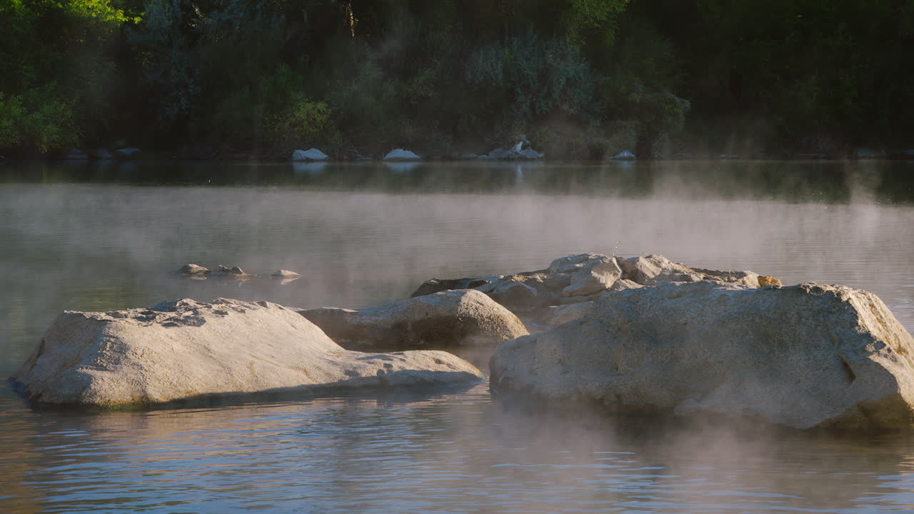 Morning Mist Rising From The Water Of River With Rocks. - zoom out shot
