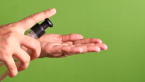 young women using hand sanitizer against green screen