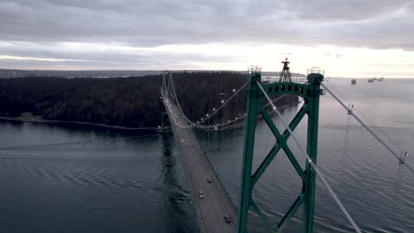 cars crossing burrard inlet on lions gate bridge at sunset, vancouver in canada