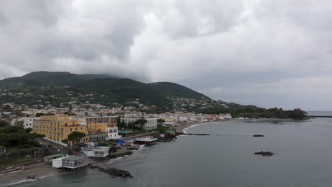 buildings on famous tourism island ischia in italy, drone backward cloudy day