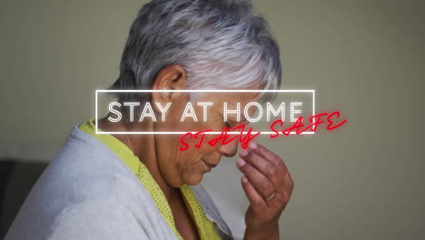 Animation of stay at home stay safe text over worried senior woman at home