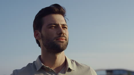 man face looking distance on nature sky. bearded guy smiling on summer sunny day