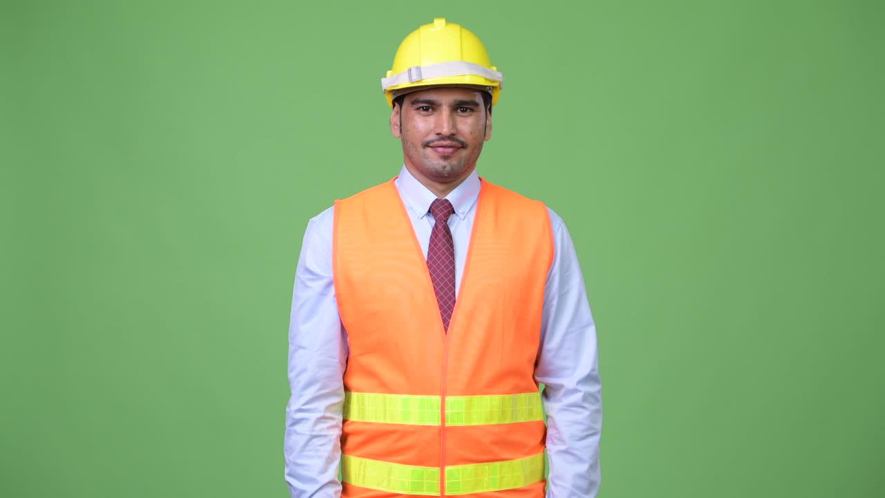 Young handsome Persian man construction worker giving handshake