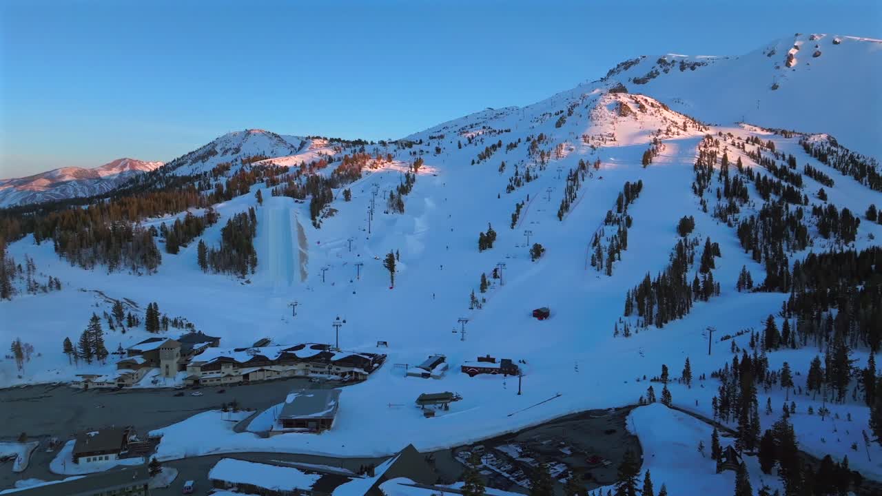 Sunset blue hour Mammoth Mountain ski resort spring Main Lodge California aerial drone Unbound Terrain Parks panorama landscape ski snowboard trail runs chairlift gondola parking lot backwards upwards