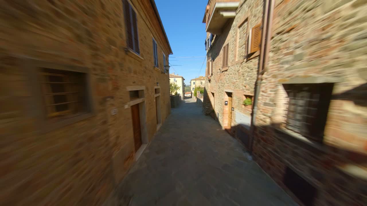 Drone che vola attraverso un vicolo nella comunità di Sinalunga, Toscana, Italia - Vista aerea.