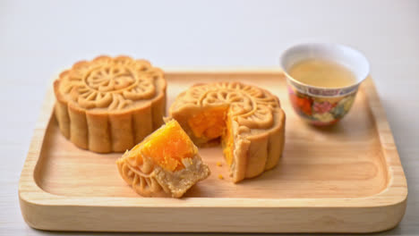 Chinese-moon-cake-durian-and-egg-yolk-flavour-with-tea-on-wood-plate