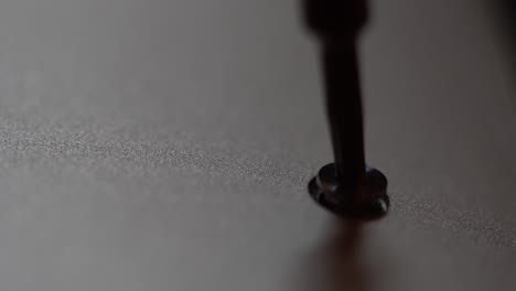 Macro-view-of-screw-being-removed-from-a-notebook