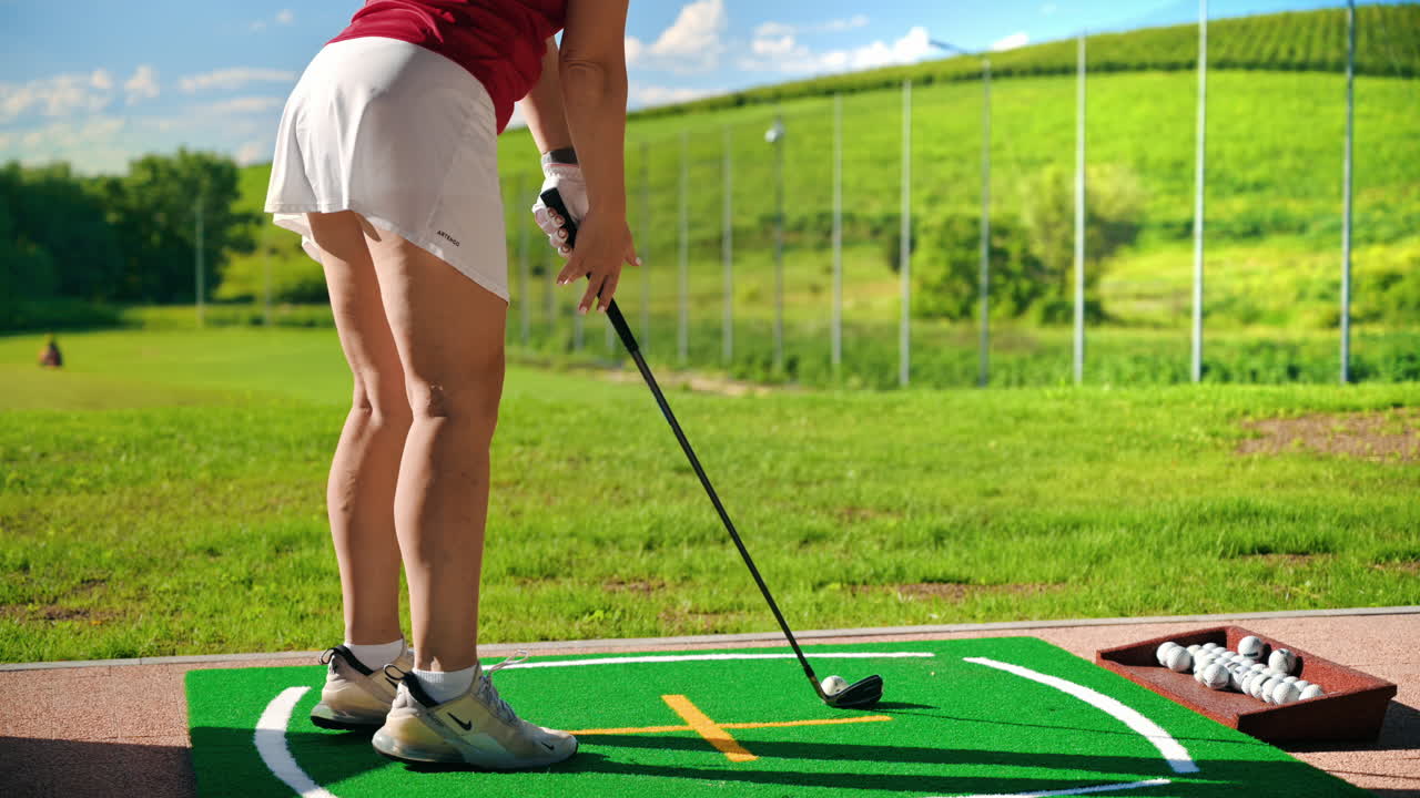 Woman in white skirt playing golf on a grass field on a sunny day