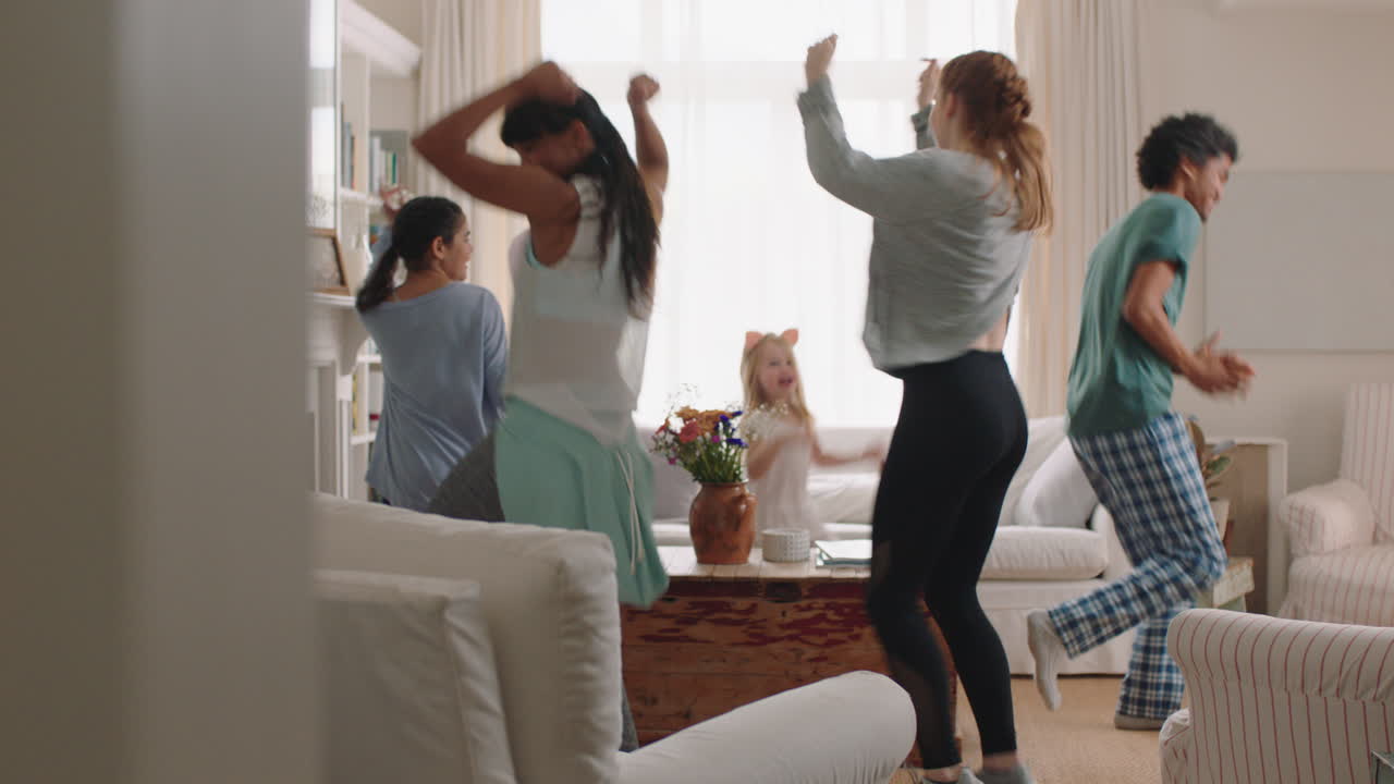 행복한 다민족 가족 집에서 춤을 추고 즐겁게 춤을 즐기고 축하하고 흥미진진한 주말을 함께 파자마를 입고