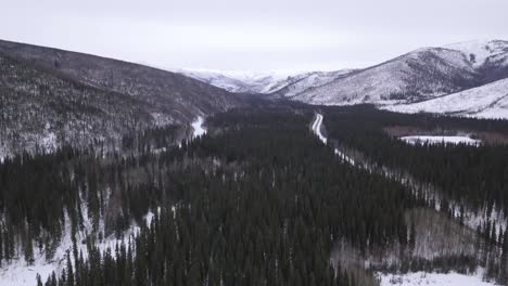 Aerial-Landscape-of-Alaska-Wilderness-Rolling-Snow-Capped-Hills,-Lush-Green-Wooded