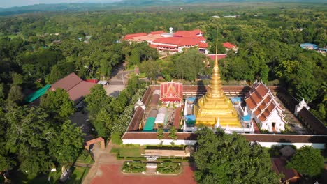 4k thai golden temple drone shot, naan province, thailand, thai traditional culture, thai buddhism wat, religion believe meditation, peaceful calm scenic, orbiting, non-urban, rural green grass land