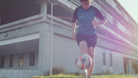 athletic girl juggling soccer ball on the street